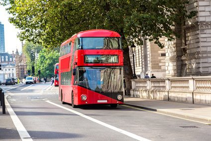 A red bus driving down the road.