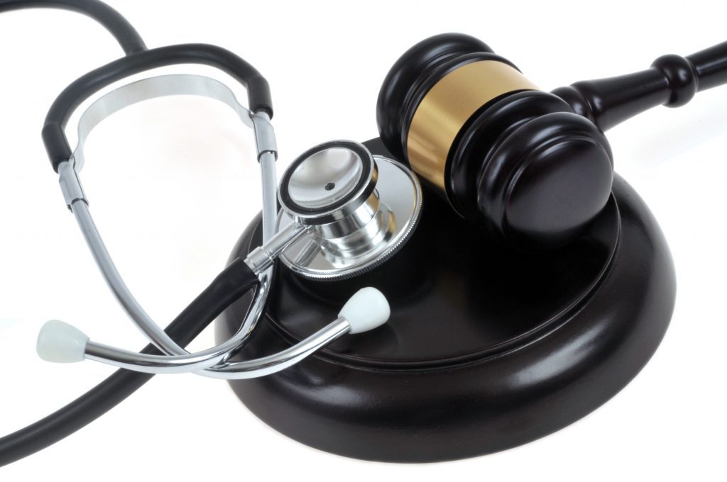 a stethoscope next to a gavel and hammer