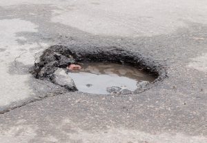 A pothole filled with water.