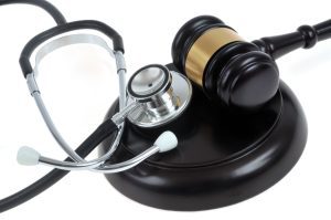 A stethoscope with a wooden gavel.