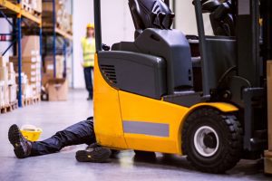 Someone's leg poking out from behind a forklift truck after being hit.