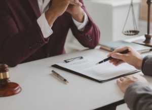 An employer data breach solicitor and client sitting at a desk discussing a contract agreement