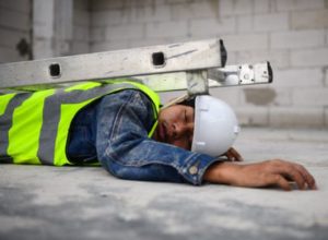 Injured worker lying on the floor with collapsed ladder on top of them
