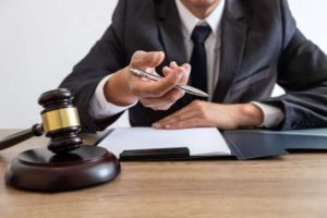 Personal injury solicitor at a desk holding a pen and paper document