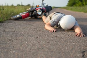 A person lays on the ground after a motorcycle accident. 