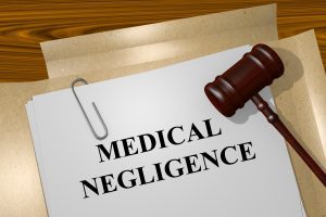 A piece of paper with the words 'Medical Negligence' on and a gavel sat on top of it.