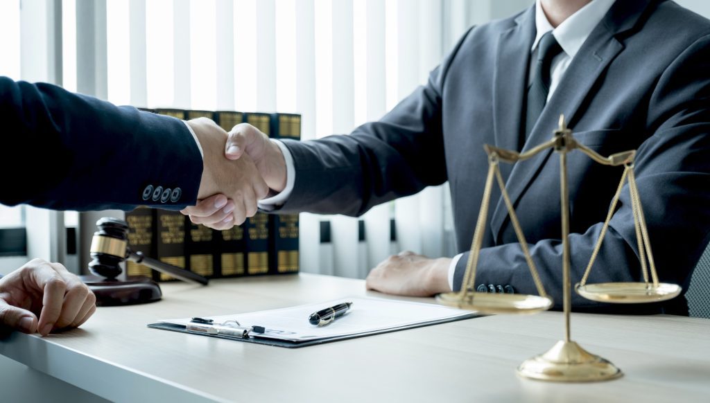 A medical negligence claims solicitor shaking hands with their client.