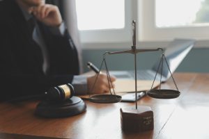 A No Win No Fee solicitor looks over meningitis negligence claims at a desk with scales on it. 