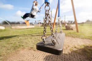 A child is on the swing in the background. 