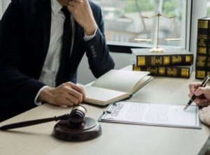 A school data breach solicitor sitting with a client who is signing a contract agreement