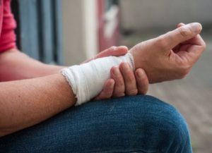 Person holding injured wrist that is covered in bandages