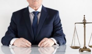 A personal injury solicitor sat at a desk with scales of justice in front of him