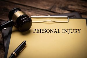 A wooden gavel and a clipboard that reads 'personal injury'.