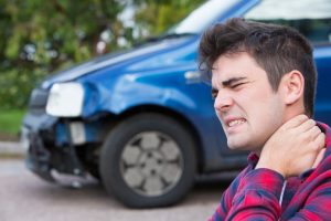 A man holding his neck following a car crash.