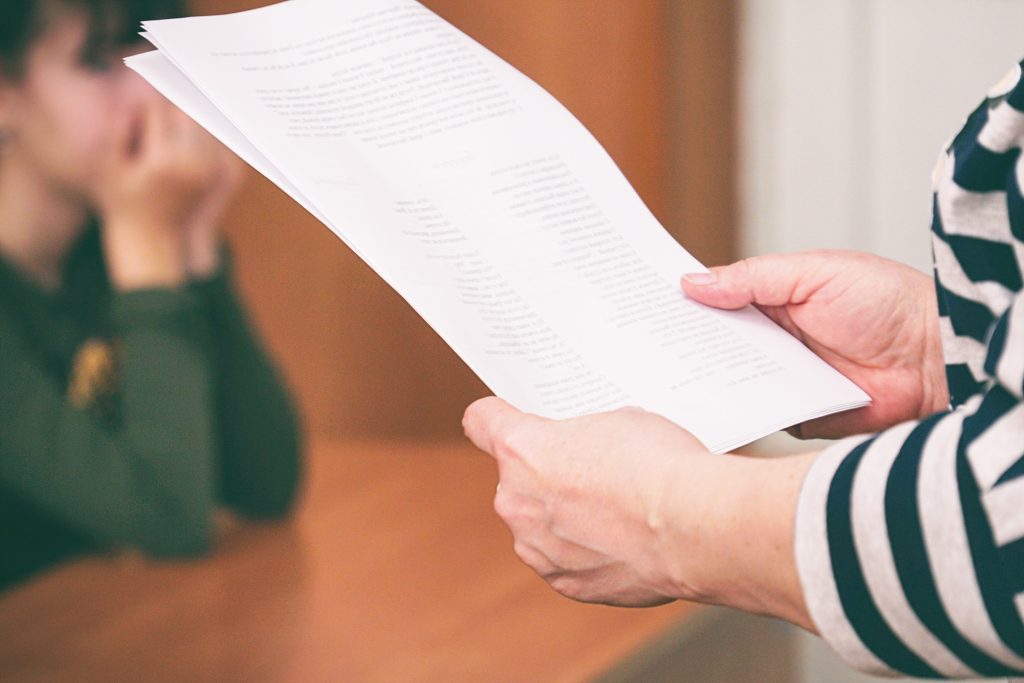 Woman is holding and looking at business papers