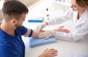 A doctor preparing a patient for a blood draw at a clinic