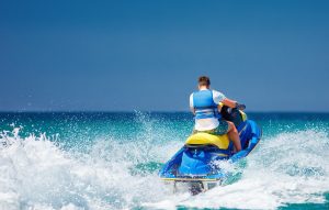 A man rides a jet ski at sea. 