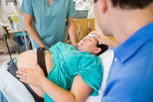 A midwife provides care to a woman in labour.