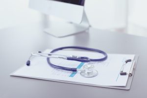 A stethoscope sitting on top of a doctor's clipboard.