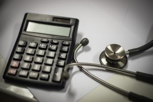 A stethoscope lying next to a calculator.