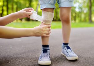 An injured child has their leg bandaged. 