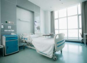 An empty hospital bed inside of a room within a hospital