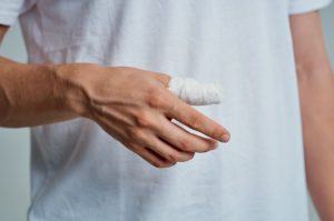 A person has a bandaged thumb.