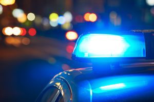 A police car performing an emergency response with blue lights flashing.