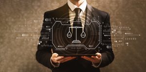 A solicitor in a black suit stands in front of digital image of scales, advising on how to claim fractured vertebrae compensation.