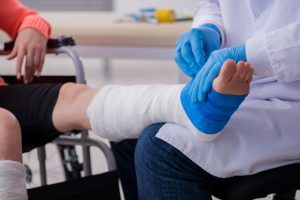 A doctor wrapping a patients foot in plaster