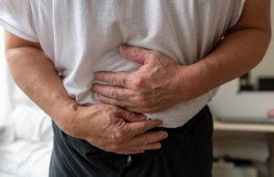 A person suffering food poisoning holds their stomach. 