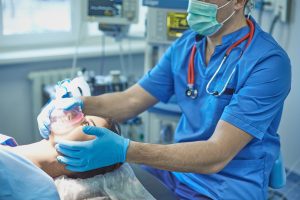 Anesthesiologist gives a patient anasthetic in an operating theathre. 