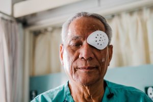 A man has a cover over one eye following eye surgery. 