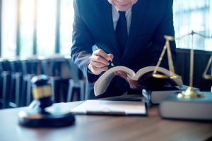 A medical negligence solicitor researches your claim at a table with a gavel and scales. 