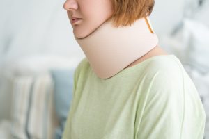 PERSON WITH NECK INJURY WEARING A CORRECTIVE BRACE