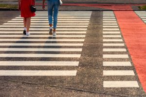 People walking across pedestrian crossing.