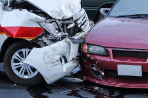 A red car collided into the rear end of a white car.