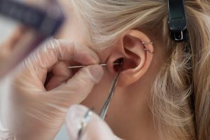 person being fitted with hearing aid after suffering permanent hearing loss