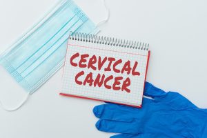 A sign that says cervical cancer next to a surgical facemask and glove 