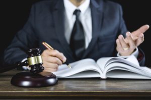 A lawyer who is an expert in cosmetic surgery claims sits at a desk.