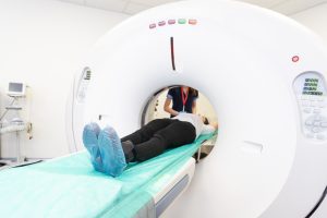 A patient receiving an MRI scan with a technician in the background