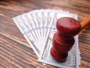 Banknotes on a table with a gavel to represent road traffic accident compensation.